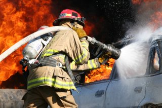 A firefighter hosing down a car or truck that's unstoppable.